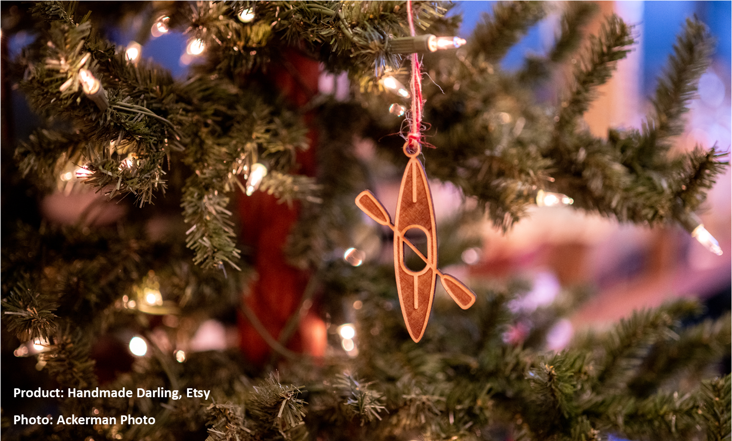 wooden kayak ornament hanging from a Christmas tree branch