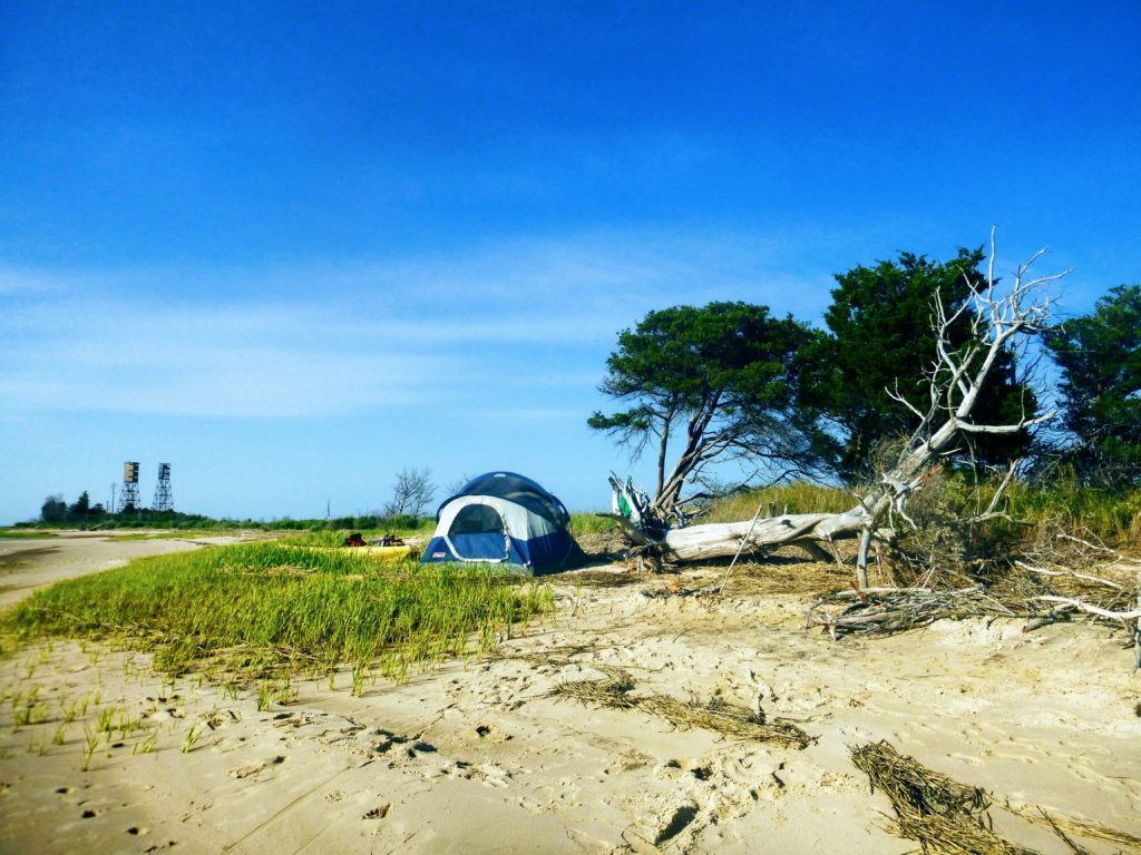 tent and two kayaks on a beach