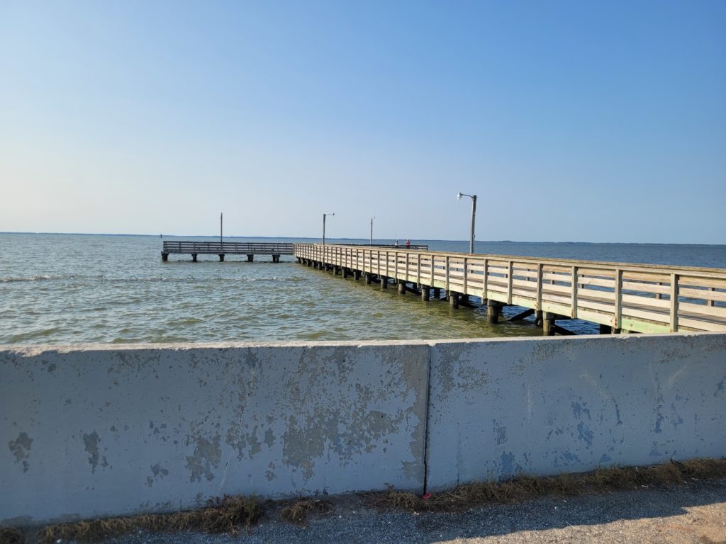 a long pier stretches out into a large body of water